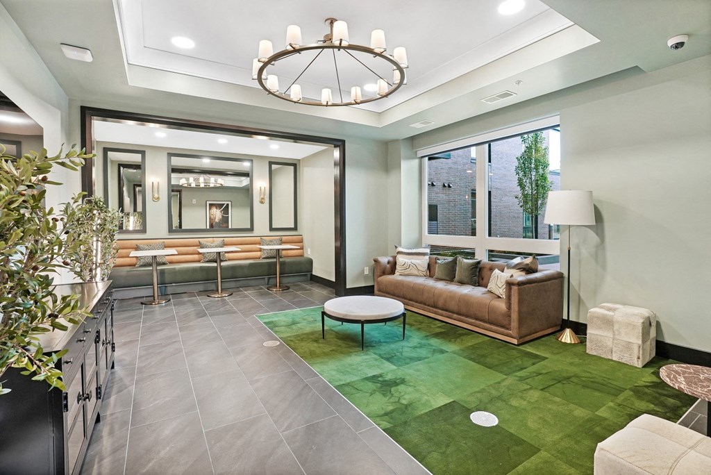 a living room with a green rug and a large chandelier