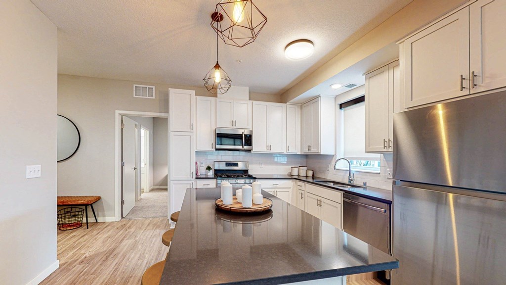 a kitchen with white cabinets and stainless steel appliances at The Morrison, Rosemount, 55068