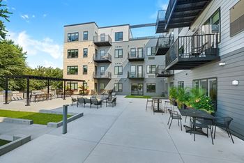 a patio with tables and chairs at the bradley braddock road station apartments