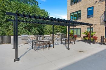 a patio with a pergola and tables and chairs