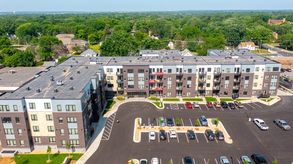 an aerial view of a large apartment complex with a parking lot and trees in the background at The Morrison, Rosemount Minnesota