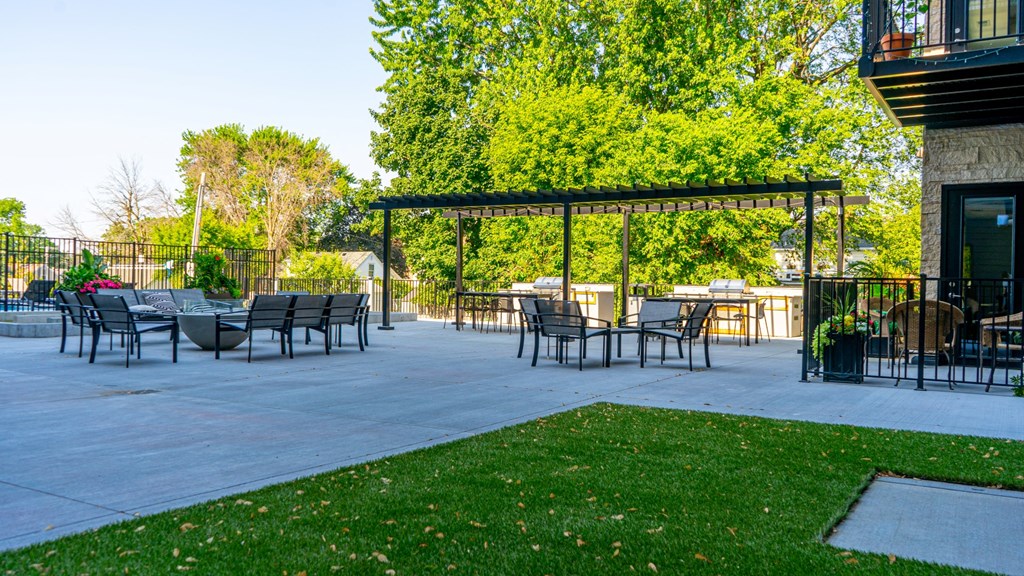 a patio with a pergola and tables and chairs at The Morrison, Rosemount Minnesota