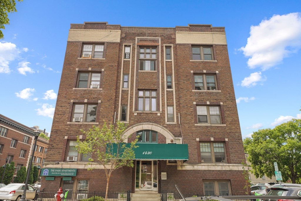a brick building with a green awning in front of it