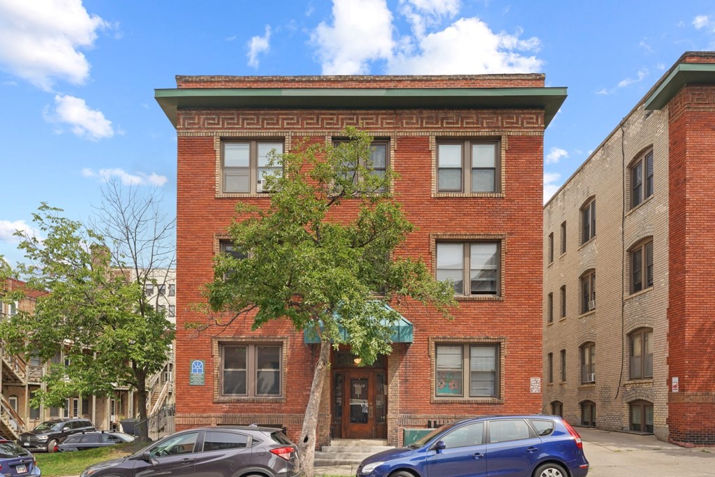 a red brick building with a tree in front of it