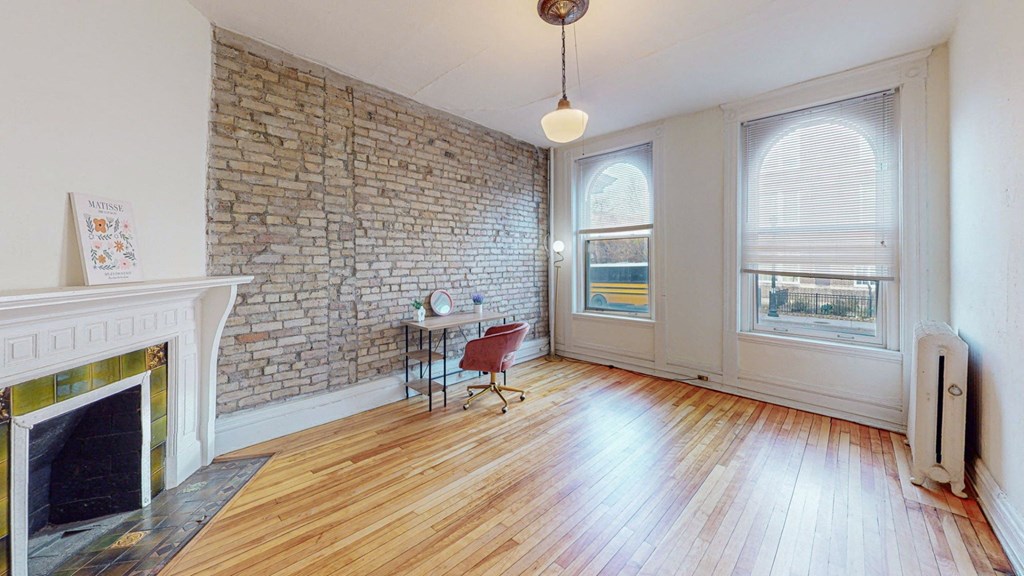 A room with a fireplace and a brick wall.