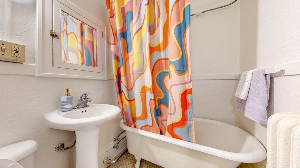 a bathroom with a bathtub sink and mirror