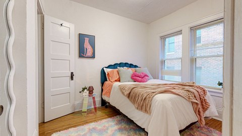 a bedroom with a bed and two windows