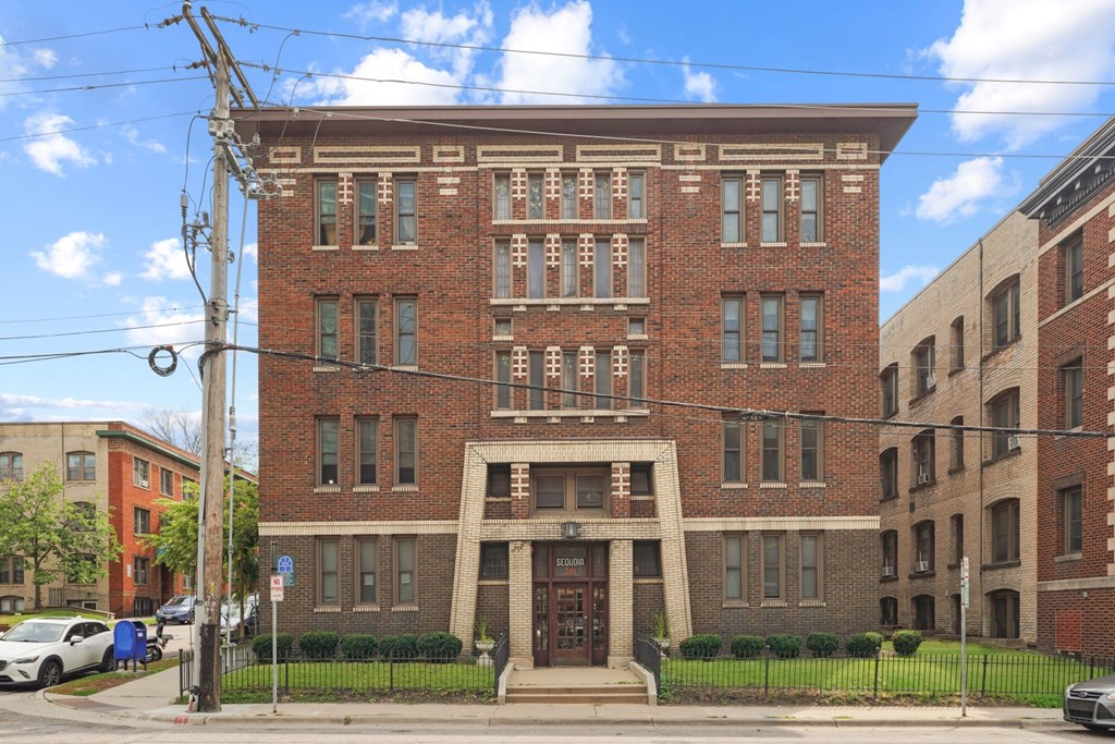 a red brick building with a large doorway and a black wrought iron fence in front of it