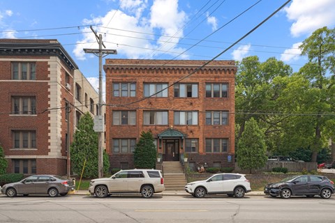 a brick building on a street corner with cars parked in front of it