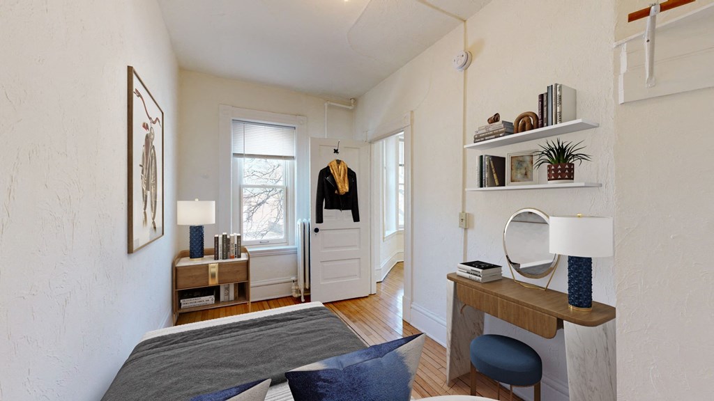 a small bedroom with a bed and a desk