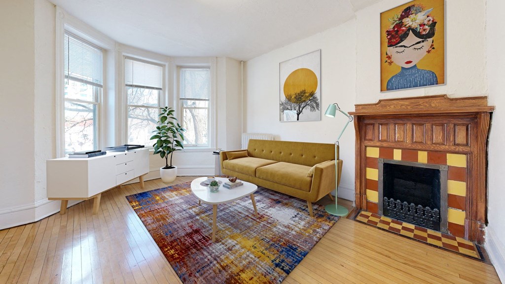 a living room with a yellow couch and a fireplace