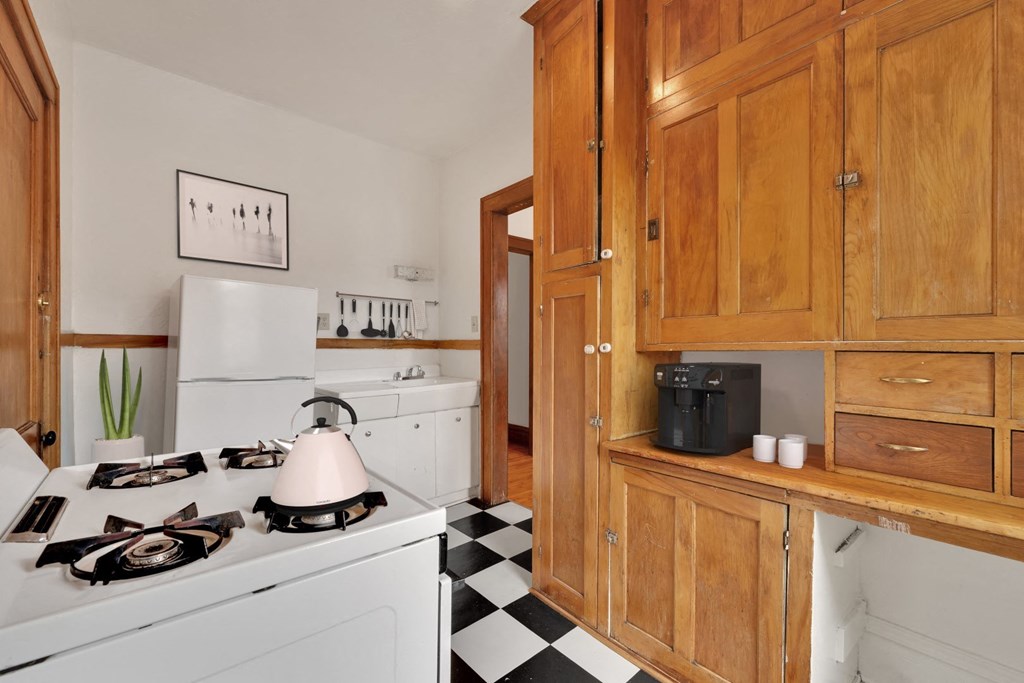 a kitchen with wooden cabinets and a black and white checkered floor