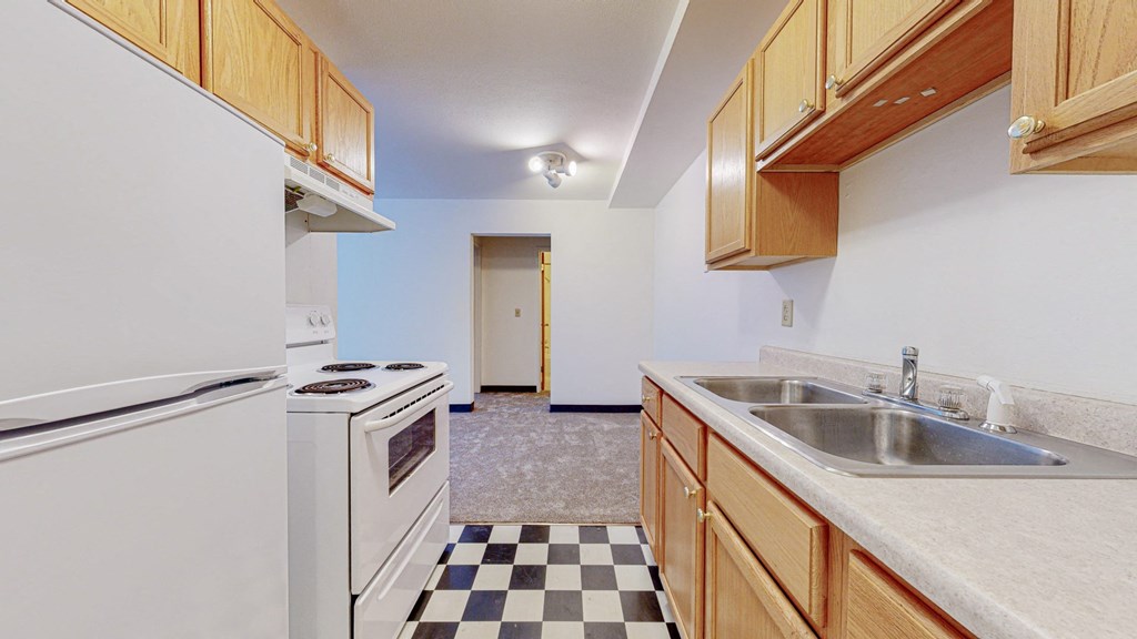 a kitchen with white appliances and wooden cabinets