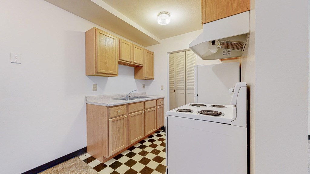 a kitchen with white appliances and a checkered floor