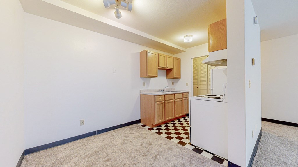 a kitchen with a white refrigerator freezer next to a stove top oven
