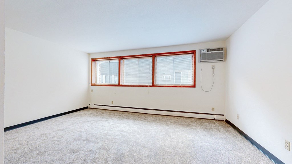 a bedroom with white walls and a large window