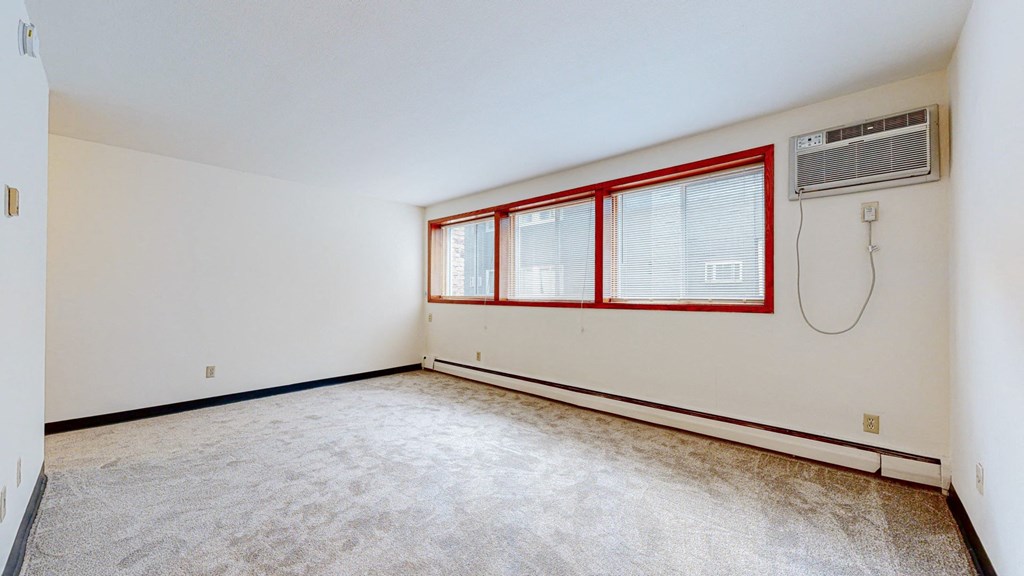 a bedroom with white walls and carpet