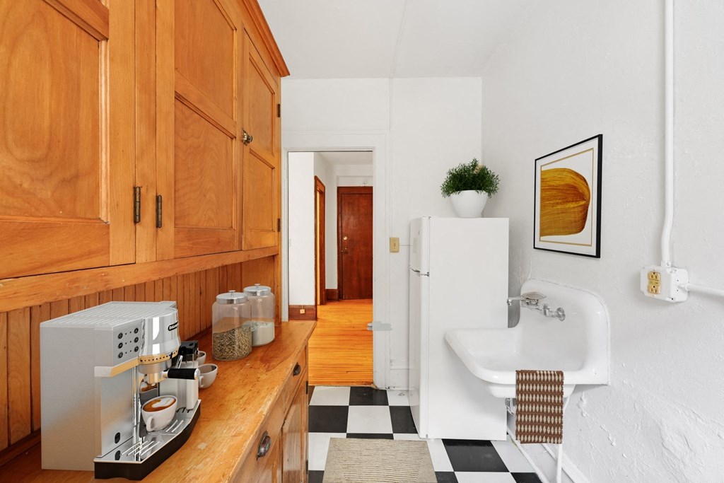 a kitchen with wooden cabinets and a black and white checkered floor