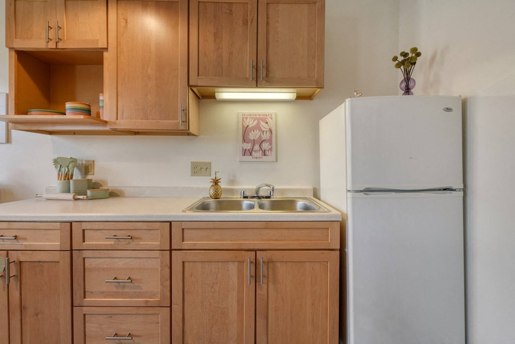 a kitchen with wooden cabinets and a white refrigerator