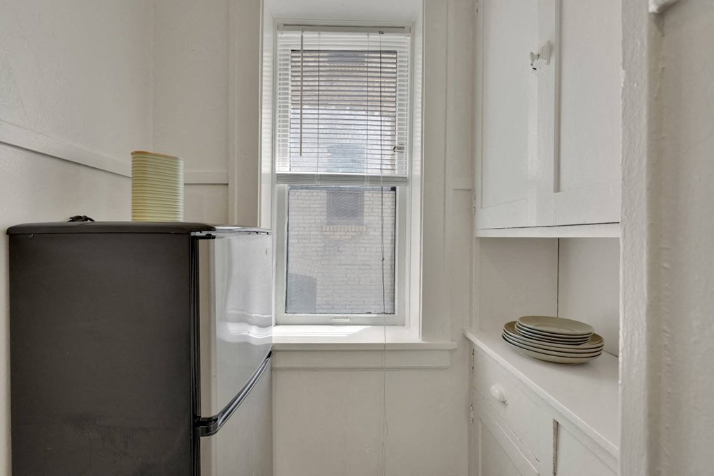 a small kitchen with a refrigerator and a window