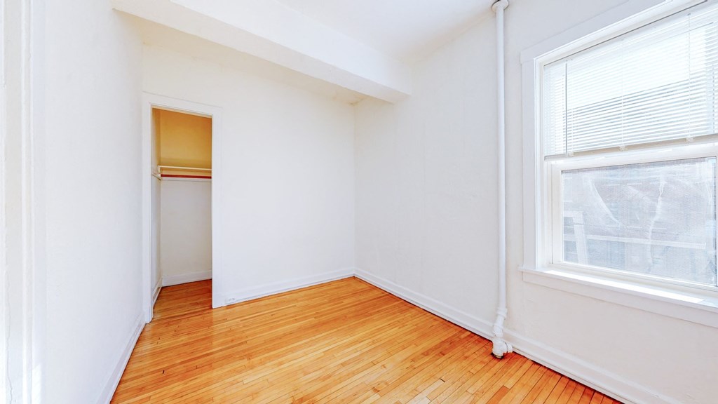 Cozy Bedroom with Restored Hardwood Floors and a Large Windows at The Park Apartments in Minneapolis, 55403