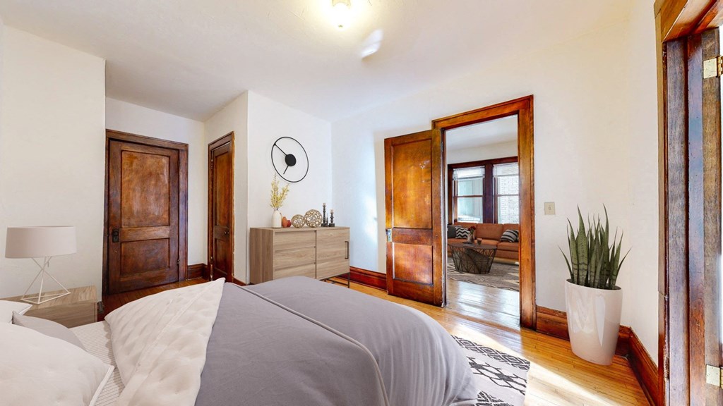 Spacious Bedroom with Accent Dark Wood Trim and Hardwood Flooring at The Park Apartments in Minneapolis, MN
