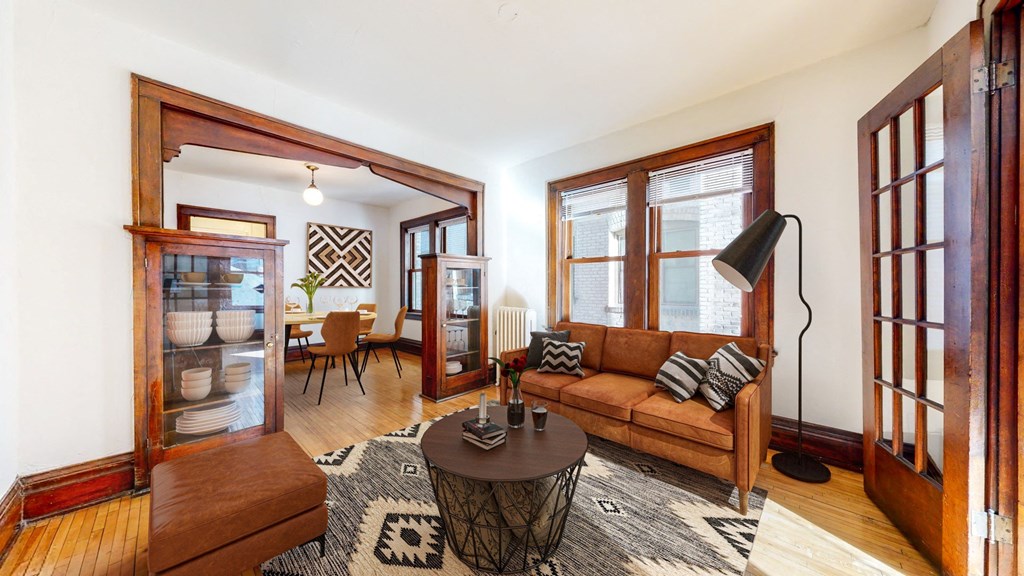 A Spacious Living Room with Retro Feel with Dark Hardwood Trim and Natural Light Streaming in from Large Windows at The Park Apartments in Minneapolis, MN, 55403