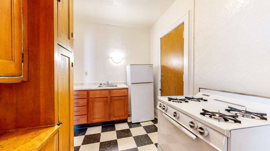 Kitchen with White Appliances and Retro Checkered Flooring at The Park Apartments in Minneapolis, Minnesota