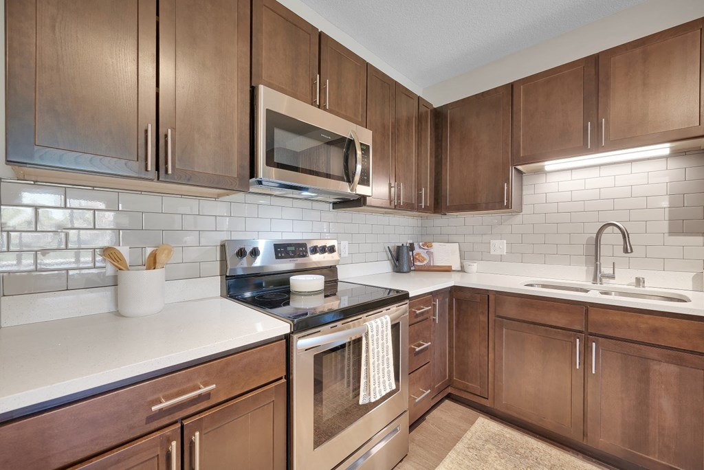 a kitchen with wooden cabinets and a stove and a microwave