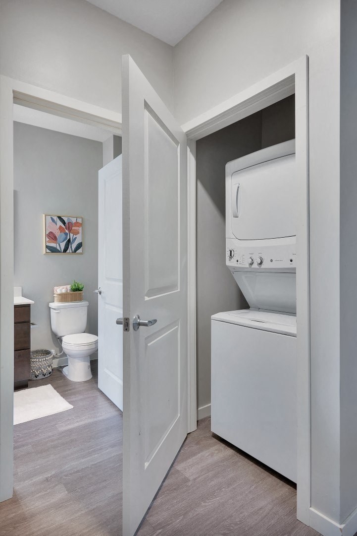 a small bathroom with a washer and dryer and a toilet