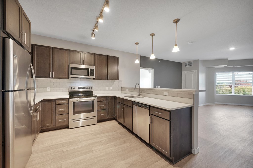 a kitchen with wooden cabinets and stainless steel appliances