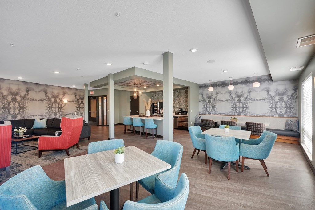 a dining room with blue chairs and tables and a lounge area