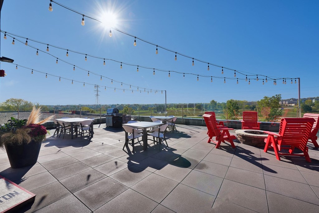 a rooftop patio with chairs and tables on a sunny day
