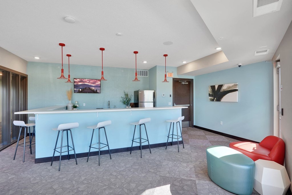 a blue bar with stools and chairs in a room with a kitchen