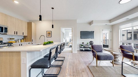 a kitchen and living room with chairs and tv