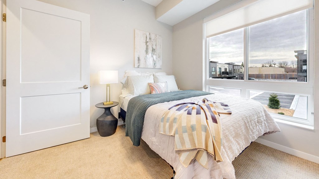 a bedroom with a bed and a large window