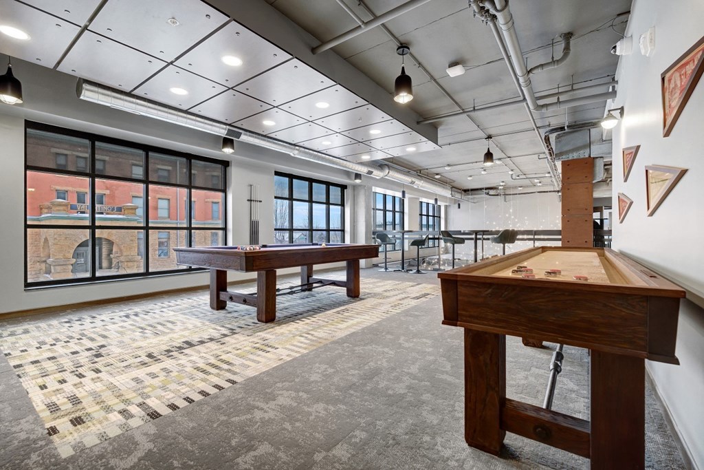 a game room with a pool table and shuffleboard