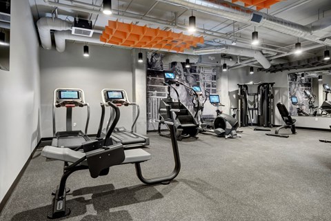 a spacious workout room with treadmills and other exercise equipment