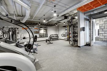 fitness cneter with black rubber floors, strentgth and cardio equipment