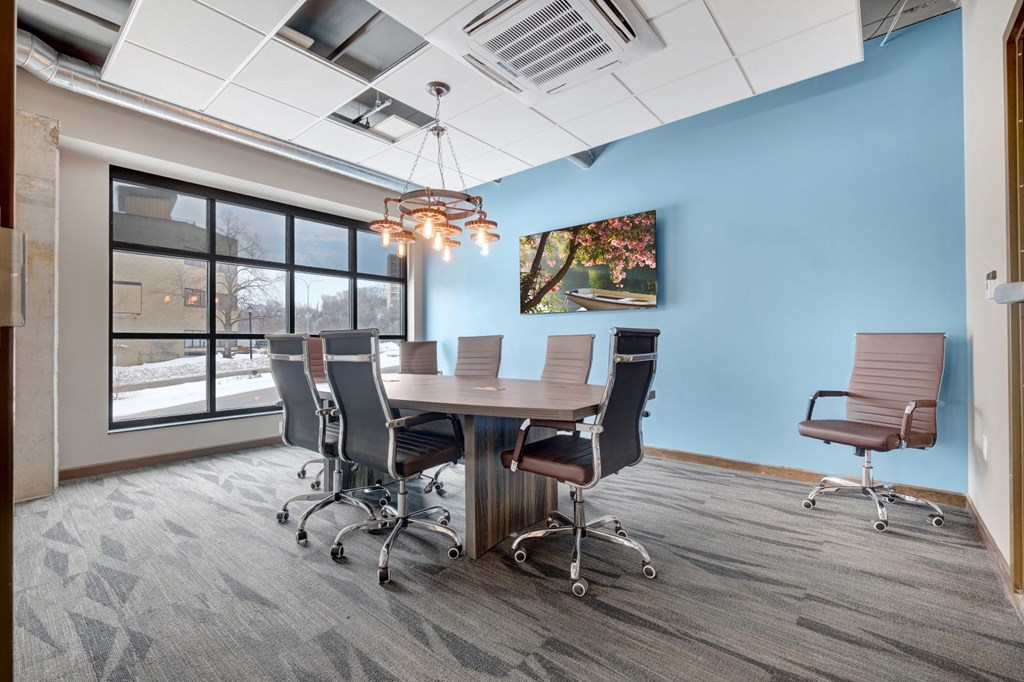 a conference room with a table and chairs and a large window