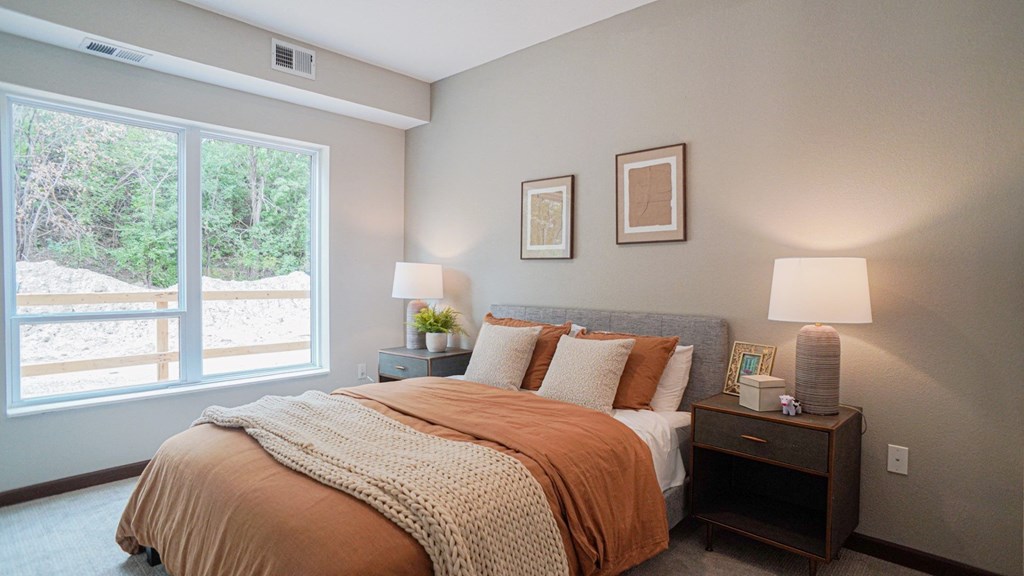 Bedroom with cozy bed and lamps at The Yards, South St. Paul, MN, 55075