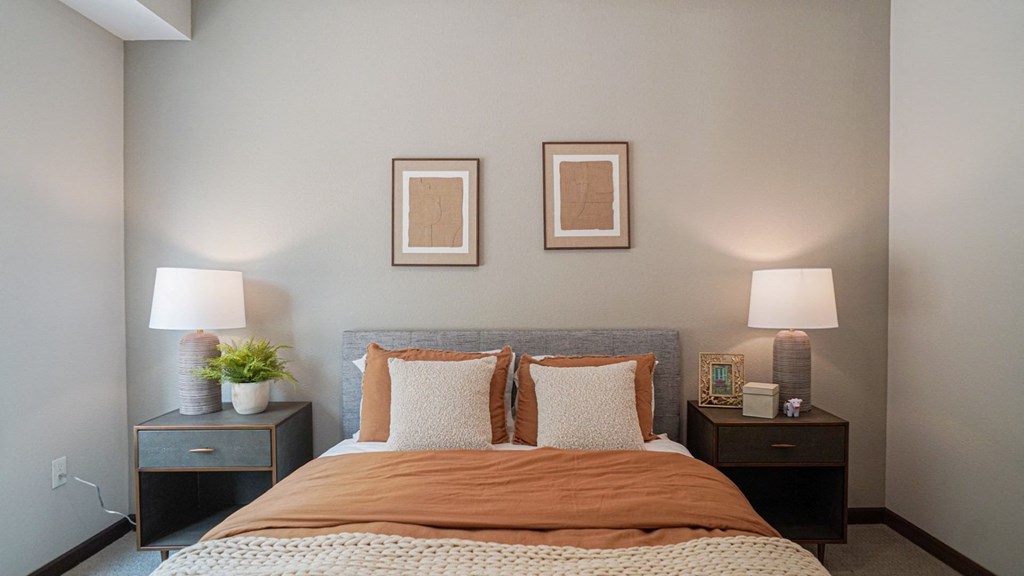 a bedroom with a bed and two night stands with lamps at The Yards and Backyards, Saint Paul, MN