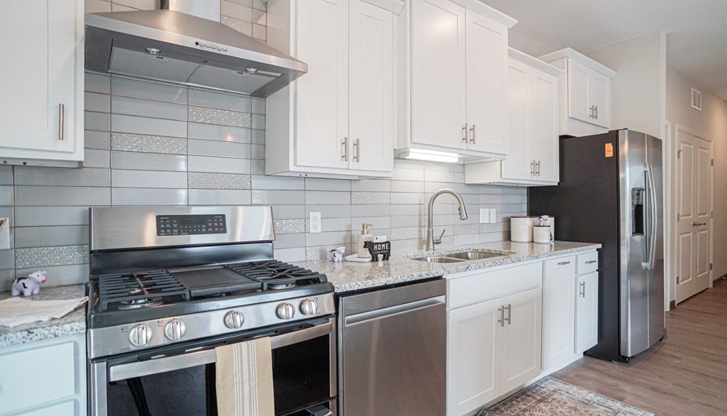 a kitchen with white cabinets and stainless steel appliances