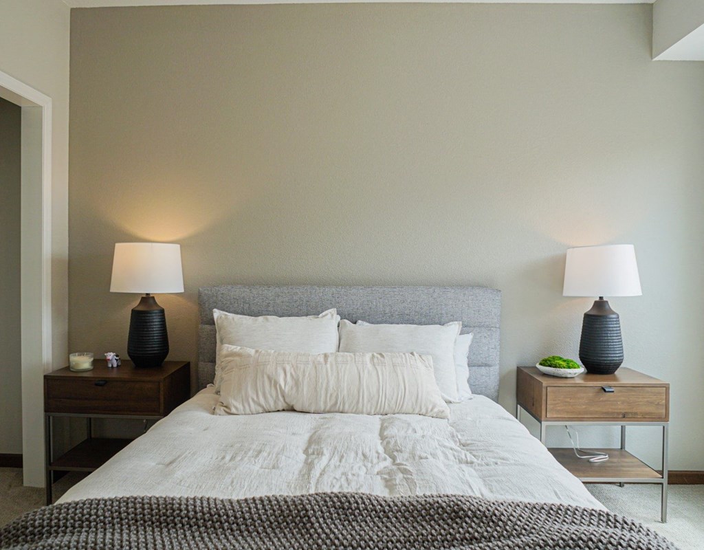 a bedroom with a bed and two nightstands with lamps on them at The Yards and Backyards, MN 55075