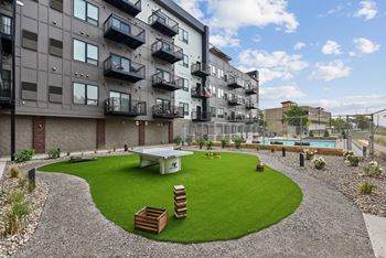 an outdoor area with a picnic table in front of an apartment building