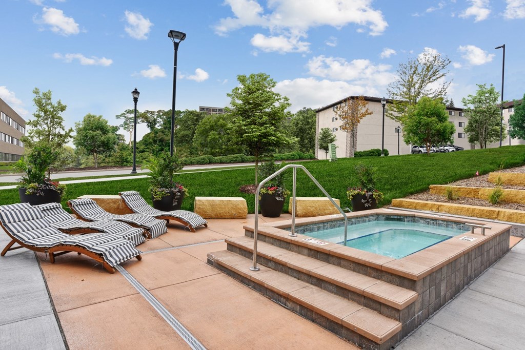 a pool and lounge chairs in a yard with a building in the background