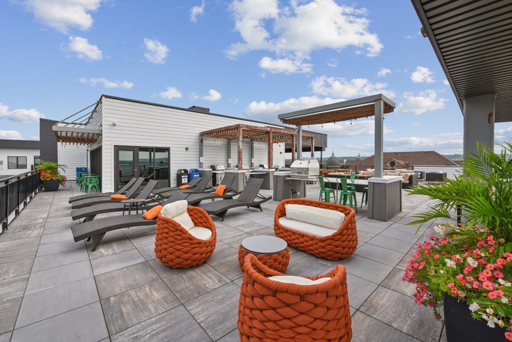a patio with chairs and tables and a building in the background