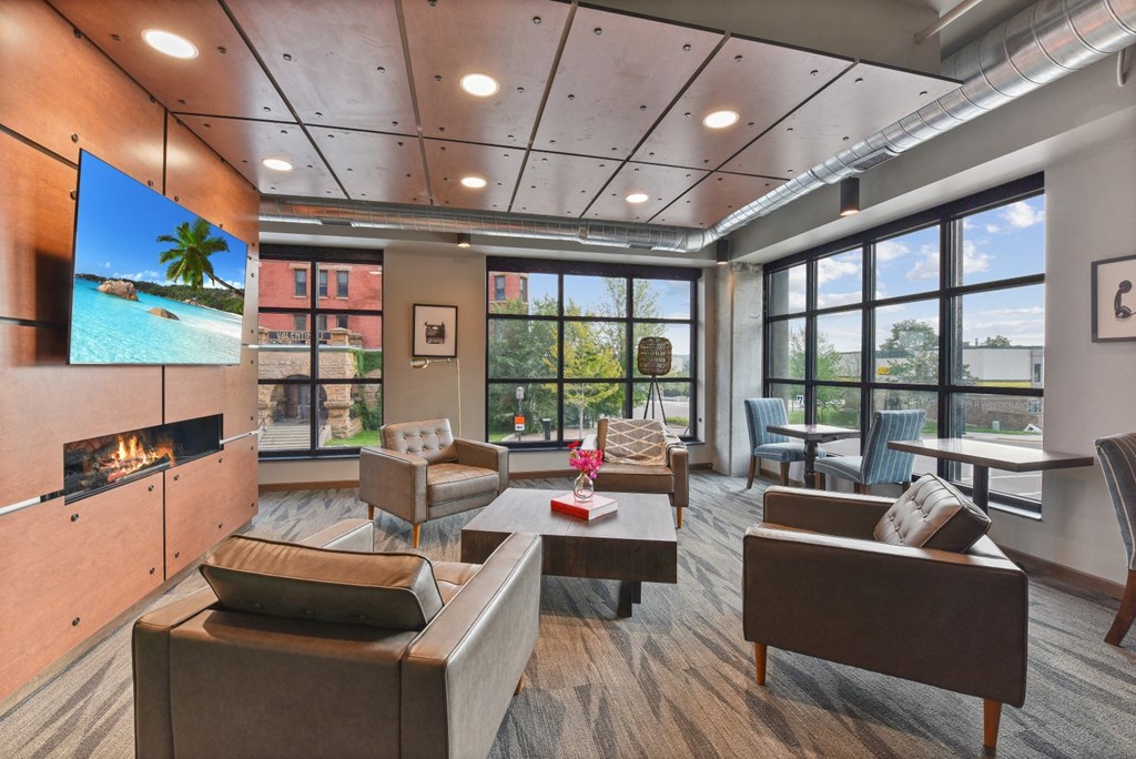 a lounge area with couches chairs and a coffee table with a vase of flowers on