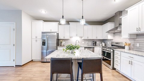 A kitchen with a table and chairs in the middle of it.