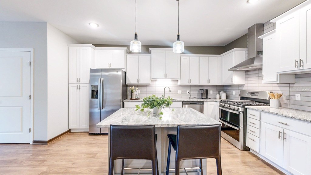 A kitchen with a table and chairs in the middle of it.